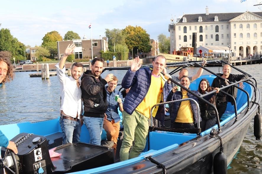 A group of people in a small boat in a body of water

Description automatically generated